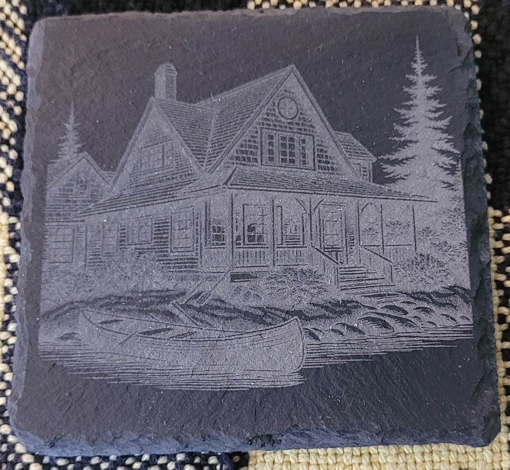 Engraved slate with a cabin and canoe design