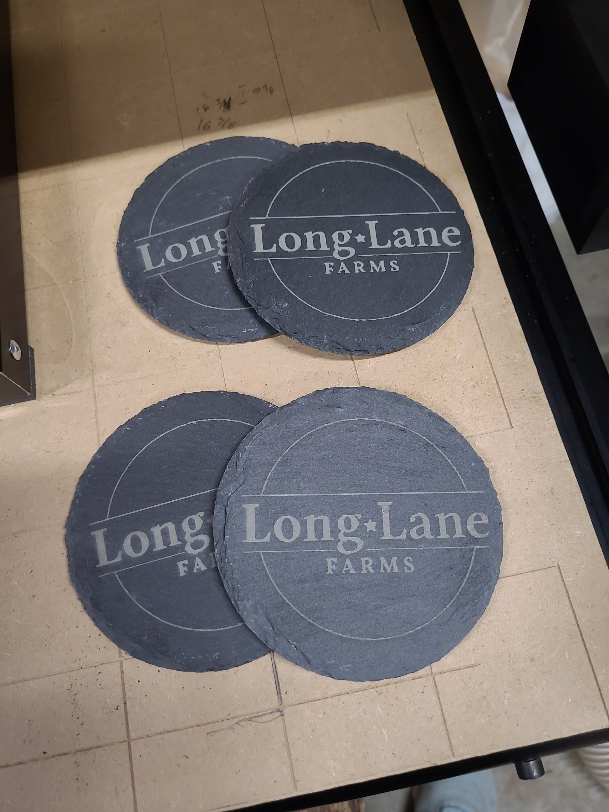 Three round blue coasters with 'Long Lane Farms' branding