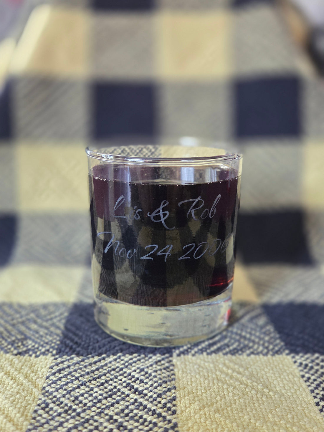 Glass tumbler with anniversary information engraved upon it.
