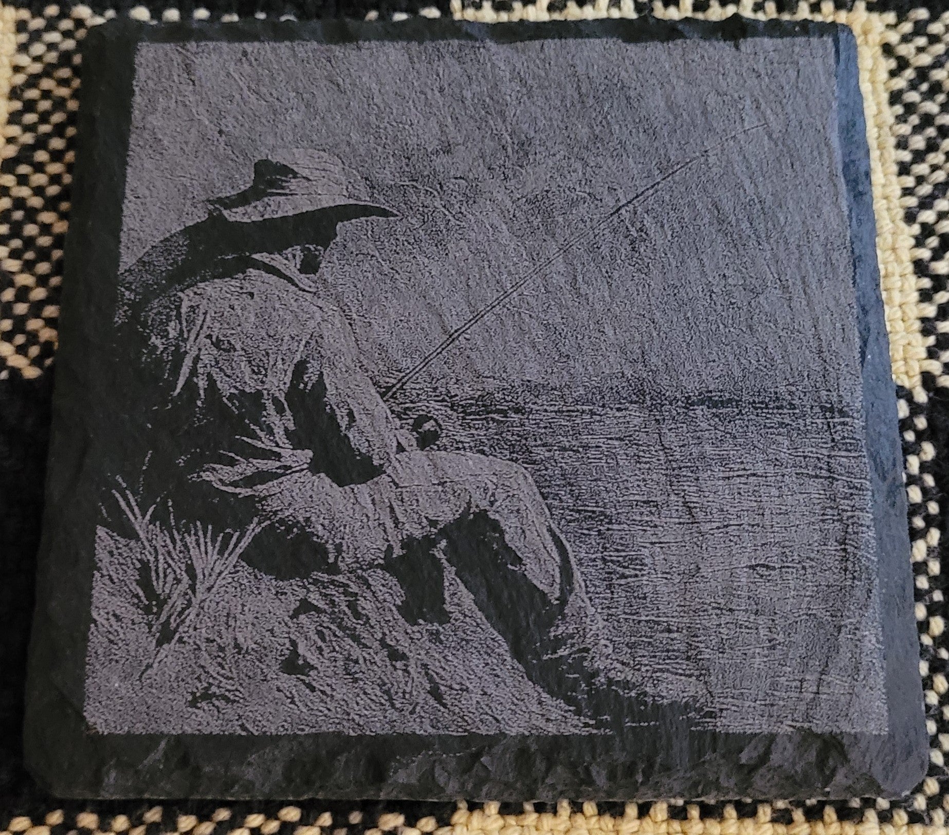 Engraved slate with a design of a person fishing
