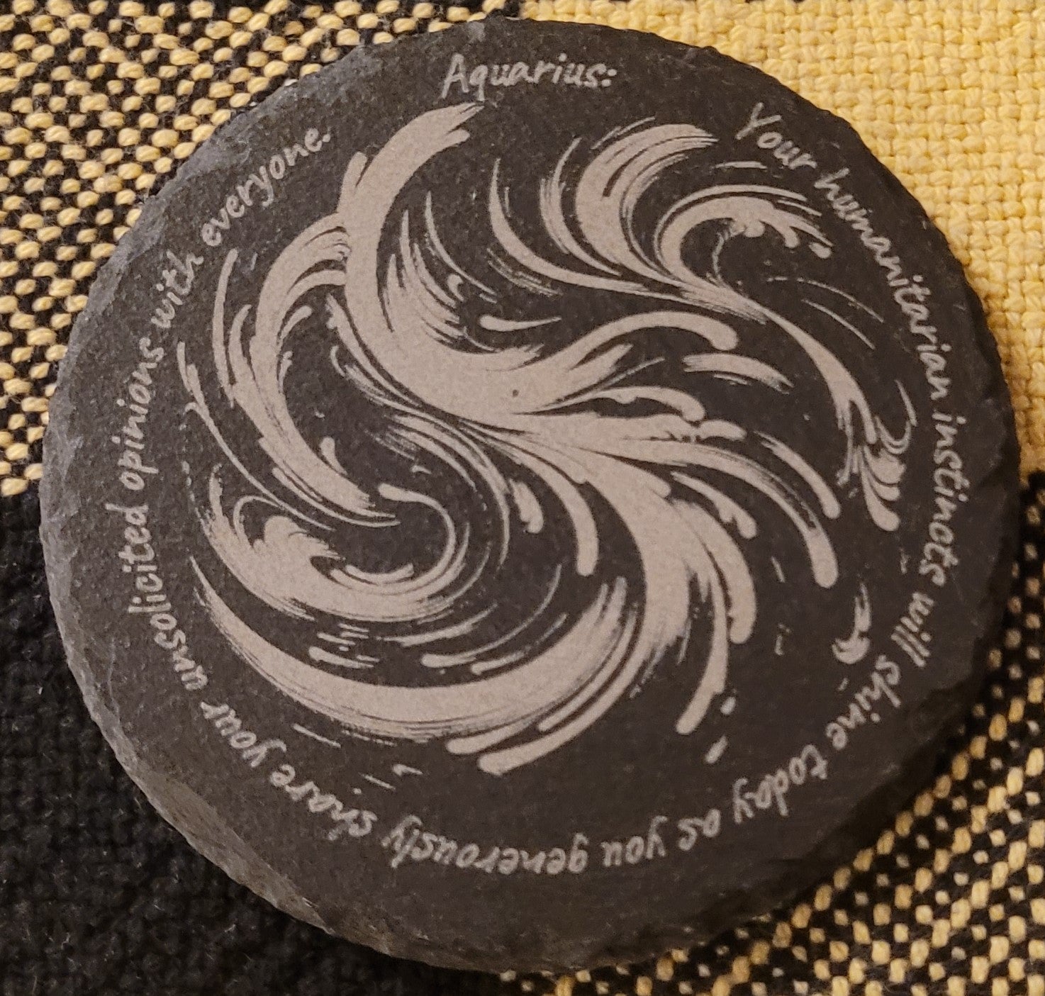 Round slate stone with zodiac design and text