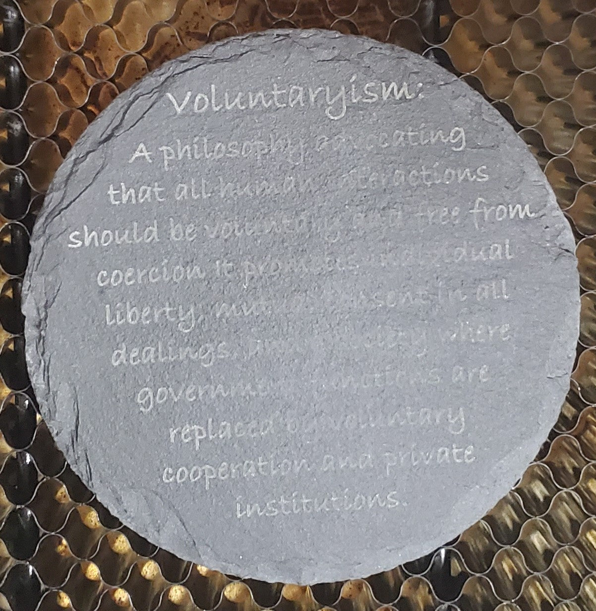Round slate stone with engraved definition of voluntarism
