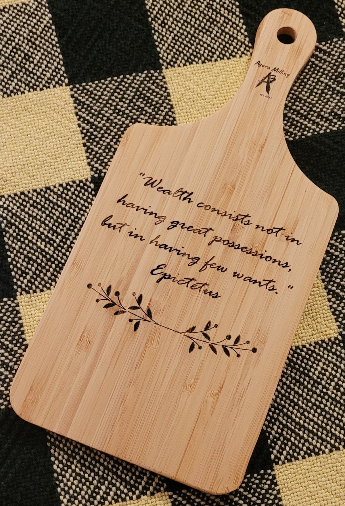 Wooden cutting board with engraved quote and branch design